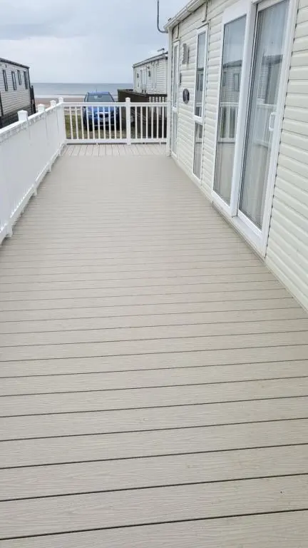 a wooden deck on the side of a house at Northern Light Villa, forest, beach and bubbles in Burghead