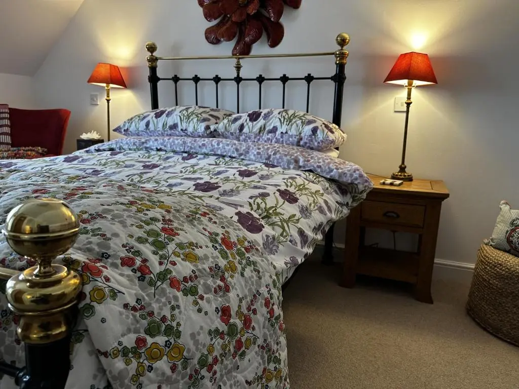 a bedroom with a bed with a floral bedspread at Sealladh Sona in Inverness