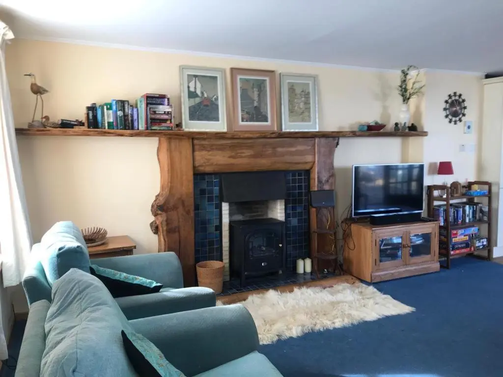 a living room with a couch and a fireplace at Idyllic beach cottage 56 Seatown Cullen in Cullen