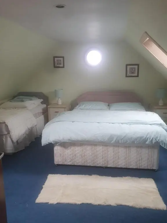 a bedroom with two twin beds and a rug at Idyllic beach cottage 56 Seatown Cullen in Cullen
