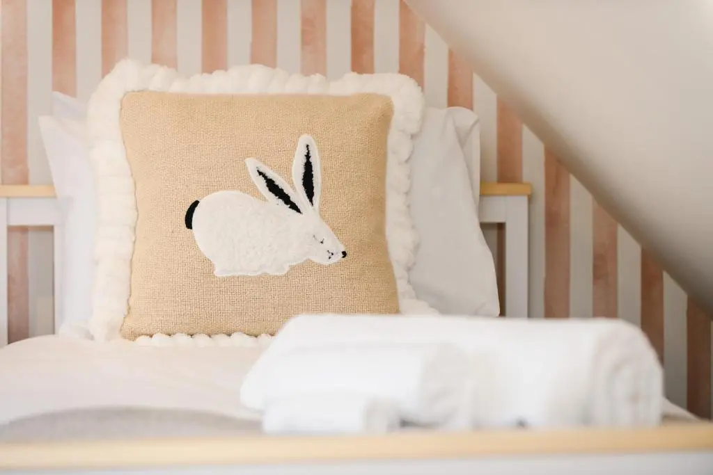 a crib with a pillow with a rabbit on it at Keel Cottage & Dog Friendly in Nairn