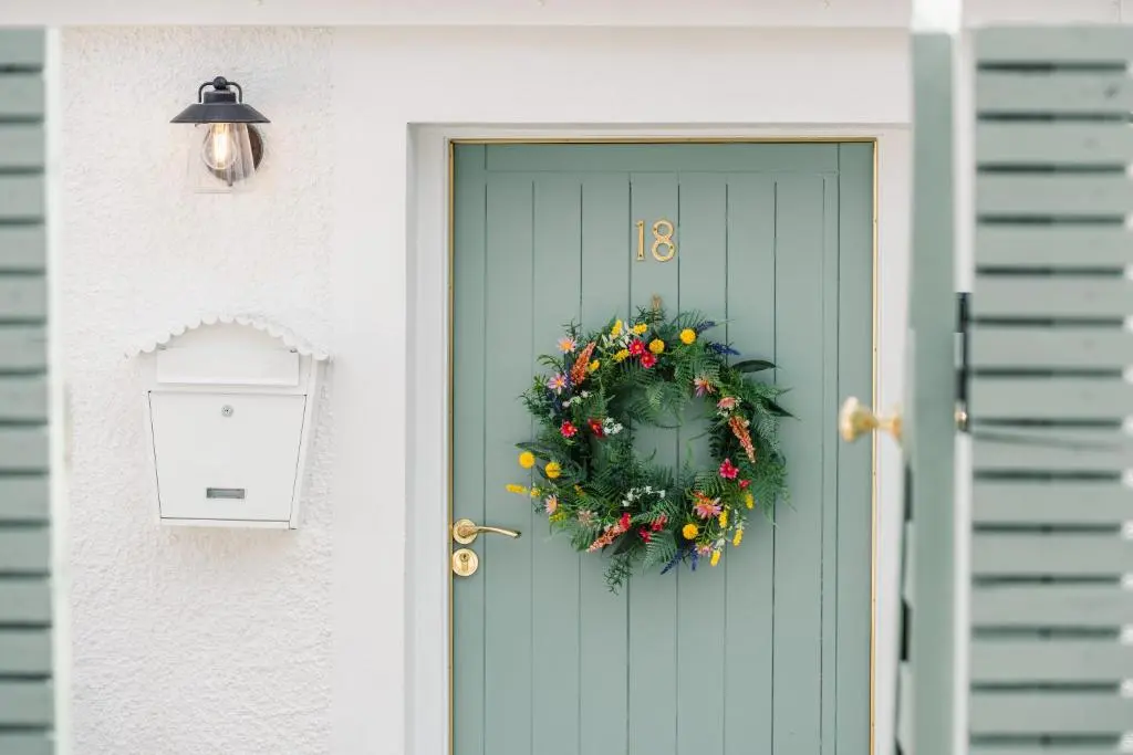 a green door with a christmas wreath on it at Keel Cottage & Dog Friendly in Nairn