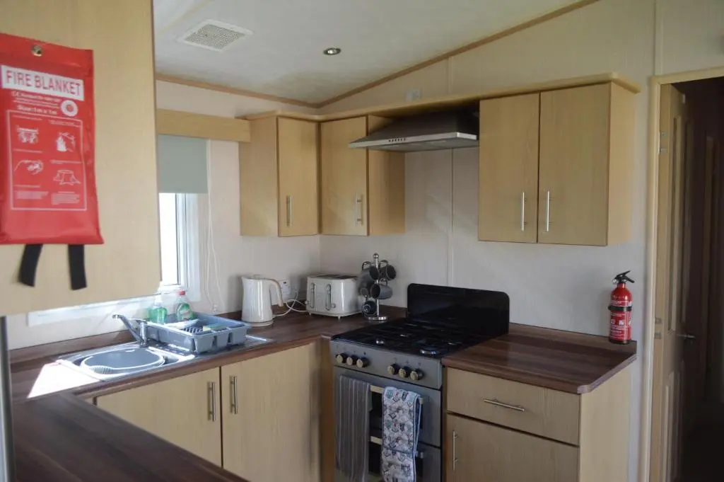 a kitchen with a sink and a stove top oven at C5, The Old Mill Caravan Park, Brodie in Dyke