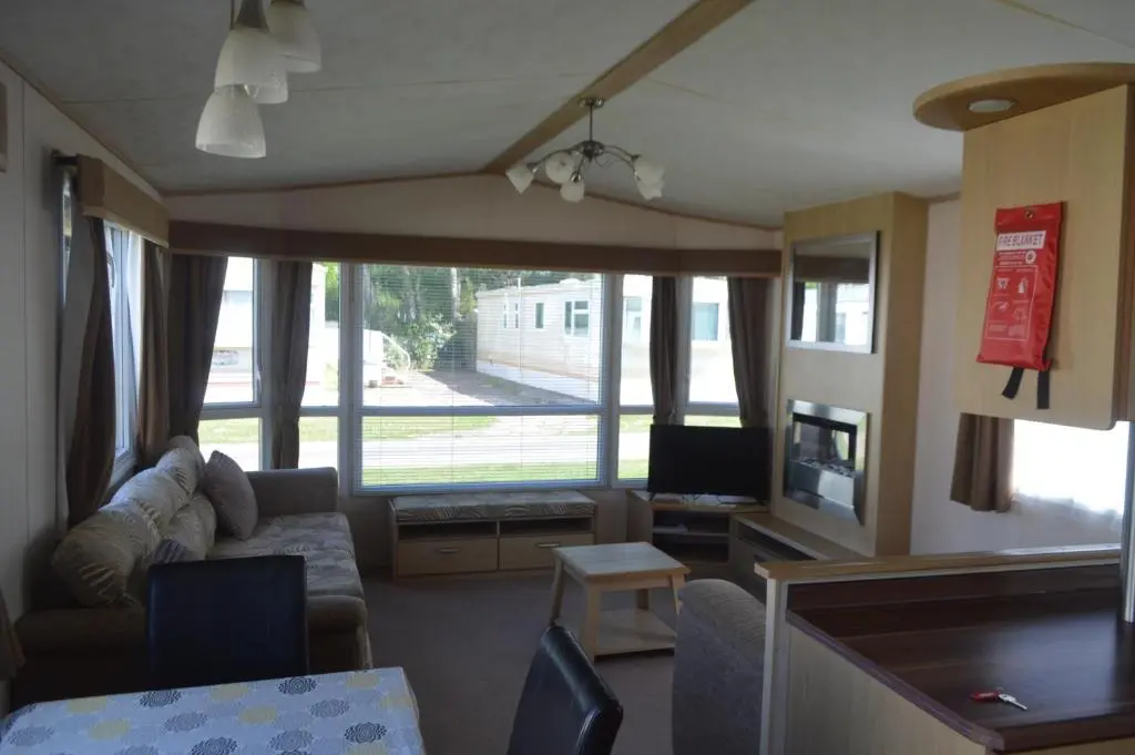 a living room with a couch and a tv at C5, The Old Mill Caravan Park, Brodie in Dyke