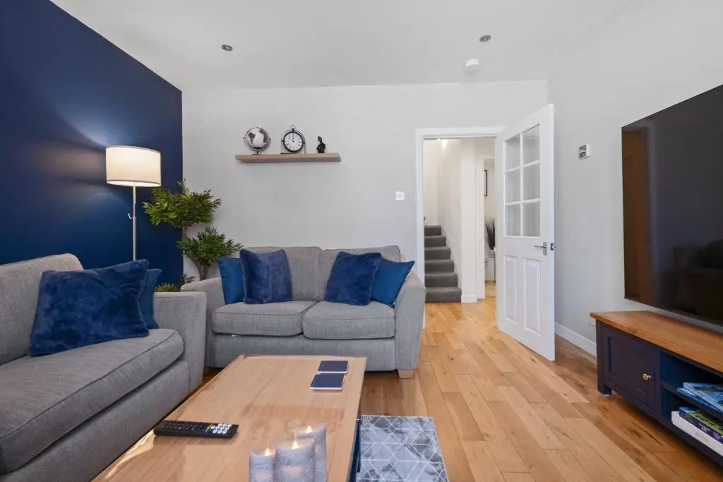 a living room with a couch and a tv at Caledonian Buildings 20b stylish city centre apartment in Inverness
