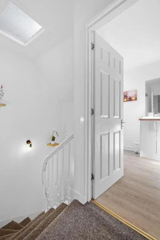 a white hallway with a white door and stairs at Caledonian Buildings 20b stylish city centre apartment in Inverness