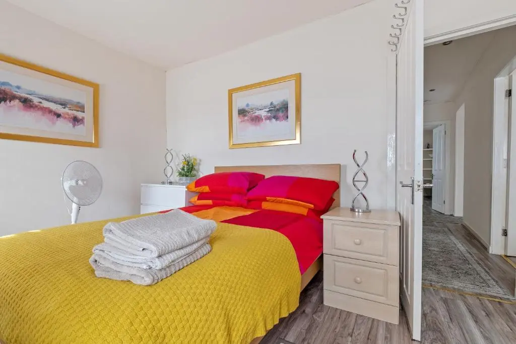 a bedroom with a yellow and red bed and a mirror at BTS 2 Bed Apart Inverness Centre in Inverness