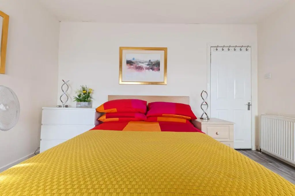 a bedroom with a large yellow bed with red pillows at BTS 2 Bed Apart Inverness Centre in Inverness