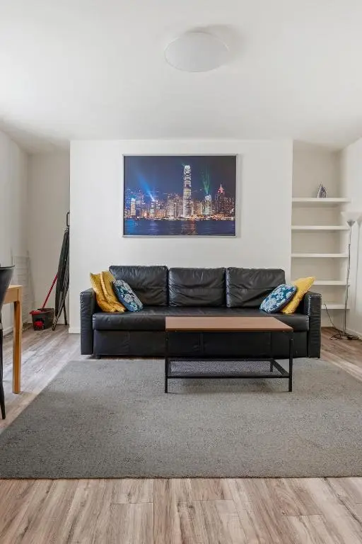 a living room with a black couch and a table at BTS 2 Bed Apart Inverness Centre in Inverness