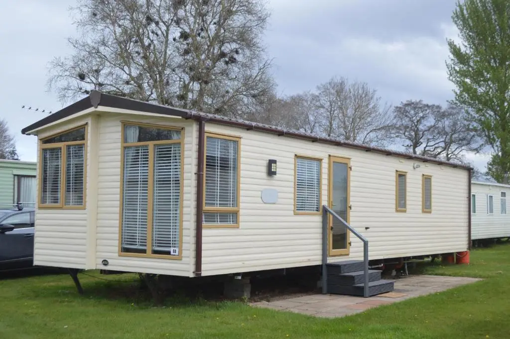 a tiny house with a staircase in a yard at B8 at The Old Mill Holiday Park in Dyke