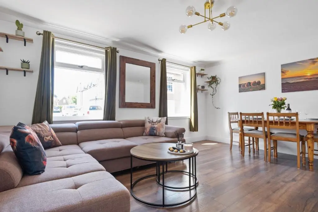 a living room with a couch and a table at Inverness Riverside Apartment with Parking in Inverness
