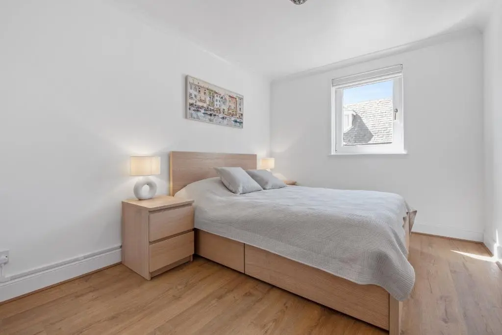 a white bedroom with a bed and a window at Inverness Riverside Apartment with Parking in Inverness