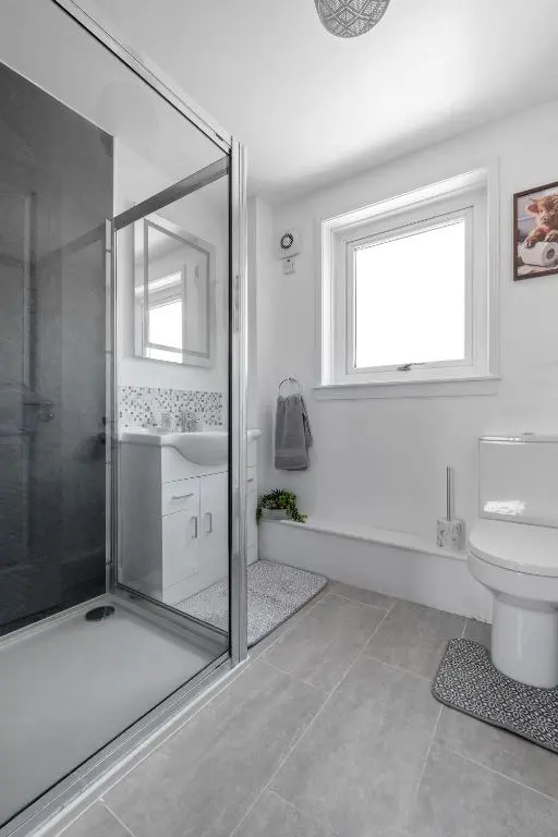 a bathroom with a shower and a toilet and a sink at Inverness Riverside Apartment with Parking in Inverness