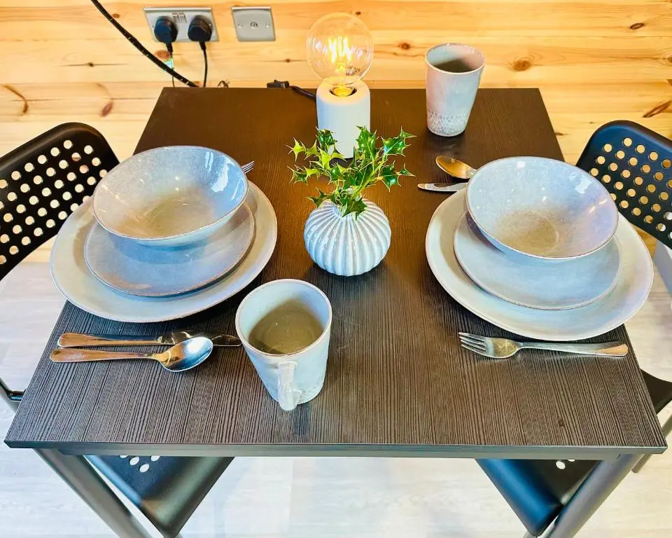 a table with plates and bowls and spoons on it at Brora Escapes in Brora