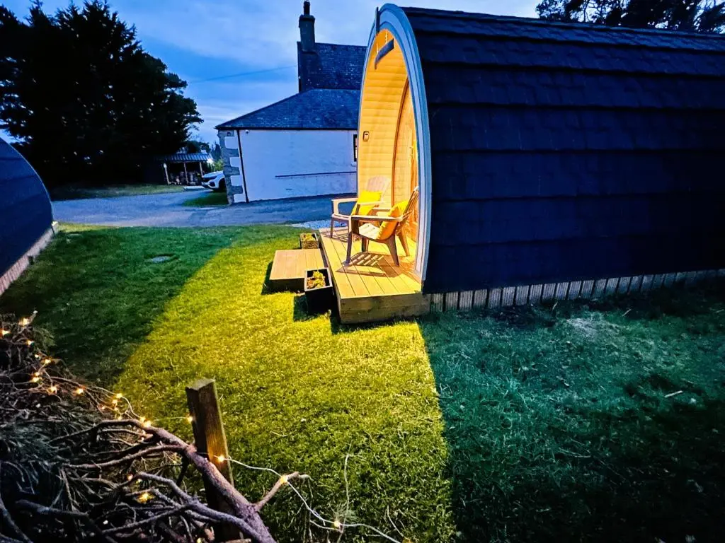 a house with a chair sitting in the grass at Brora Escapes in Brora