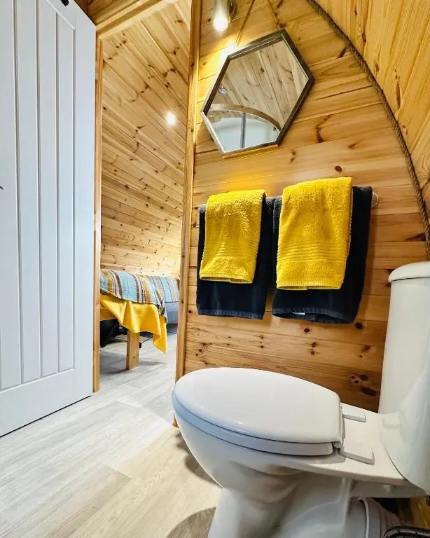 a bathroom with a toilet and yellow towels at Brora Escapes in Brora