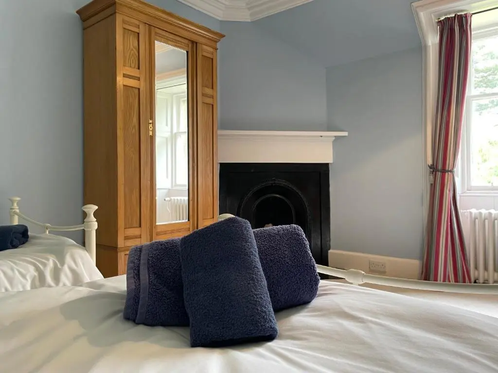 a bedroom with a bed with purple pillows on it at Glentromie Estate in Ruthven