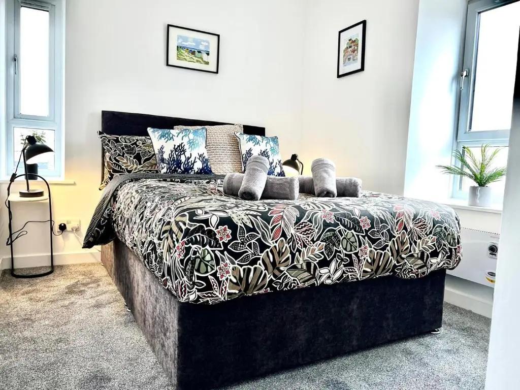 a bedroom with a bed with a black and white comforter at Harbour View Hopeman in Hopeman
