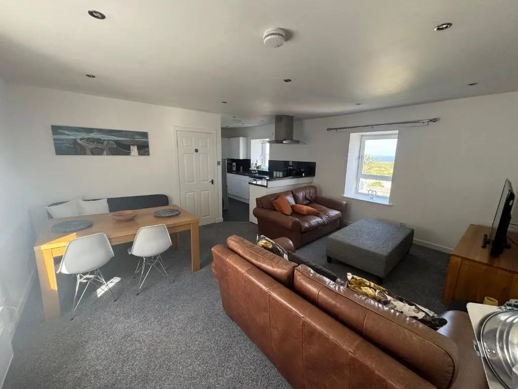 a living room with a couch and a table at Harbour View Hopeman in Hopeman