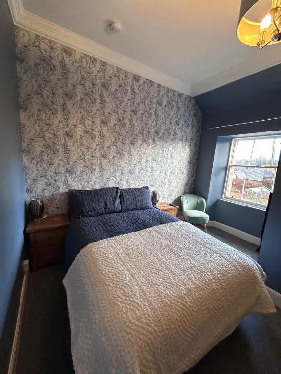 a bedroom with a bed and a wall at Gruinard Guest House in Beauly