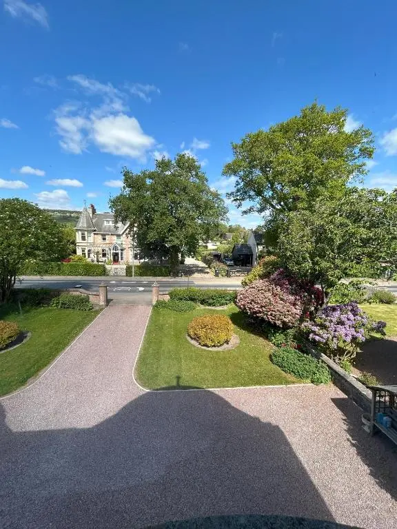 a walkway in front of a house with flowers at Gruinard Guest House in Beauly