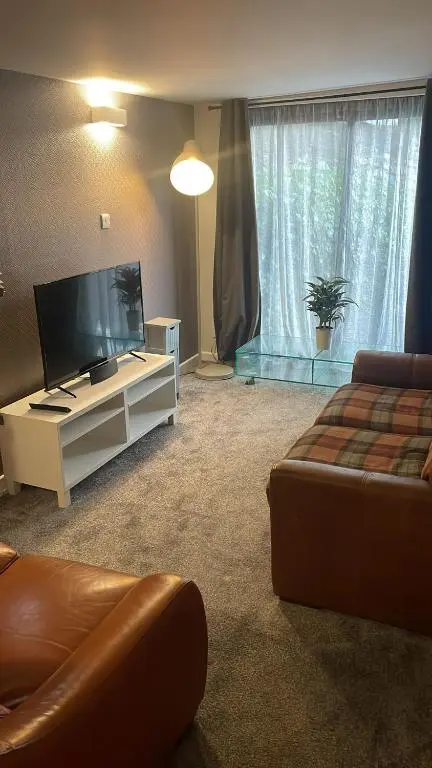 a living room with a flat screen tv and a couch at Casale Peterculter in Peterculter