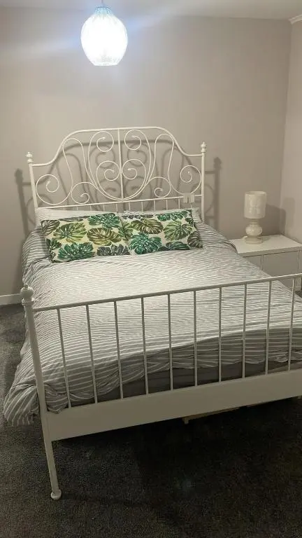a bed in a bedroom with a white bed frame at Casale Peterculter in Peterculter