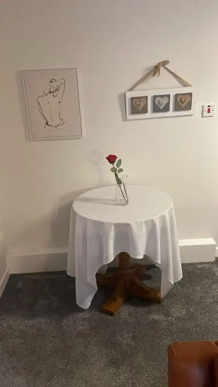 a table with a vase with a flower on it at Casale Peterculter in Peterculter