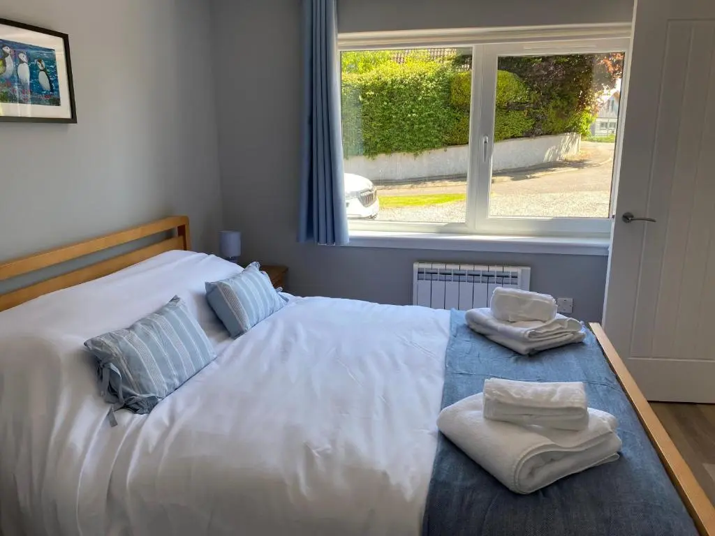a bedroom with a bed with towels on it at Stagstone apartment in Fortrose in Fortrose