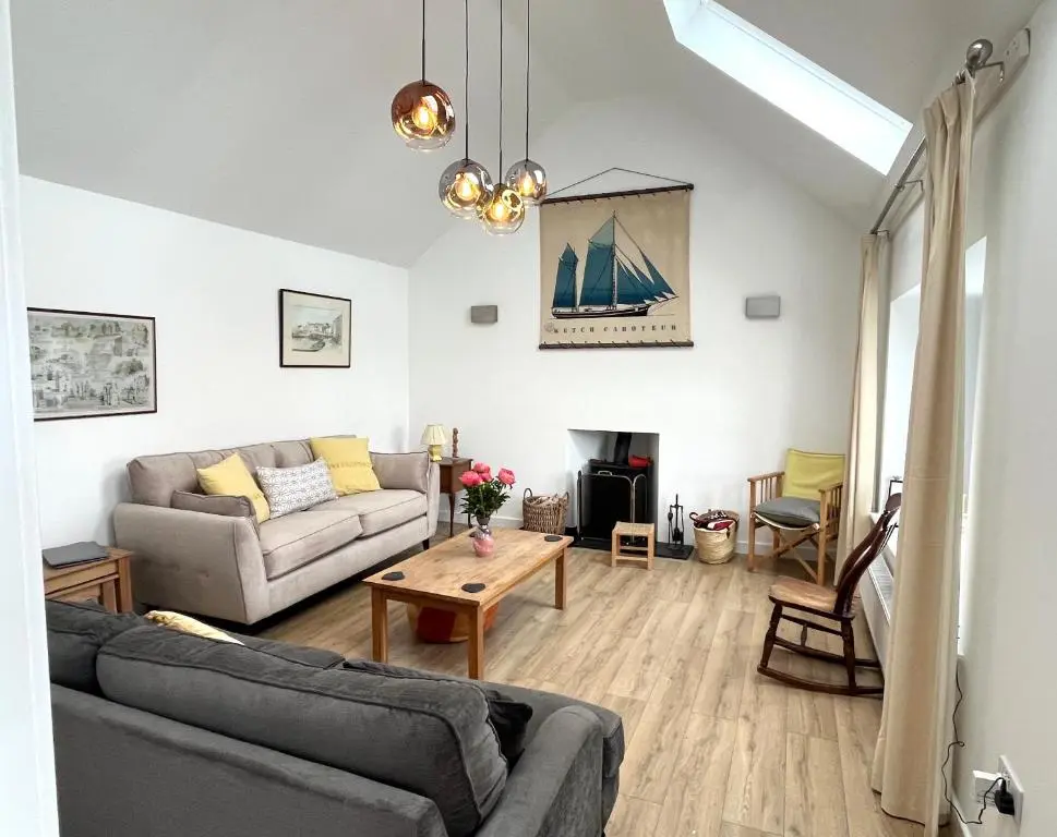 a living room with a couch and a table at House By The Sea in Portsoy