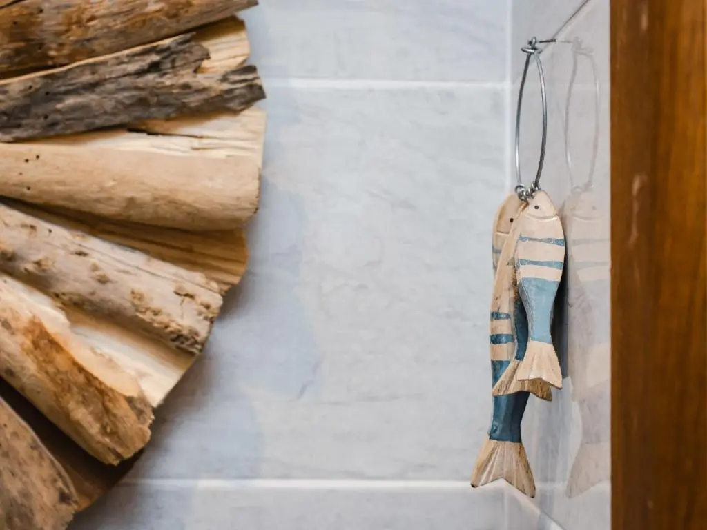 a broom hanging on a wall next to logs at Chalet Heron Lodge by Interhome in Spean Bridge