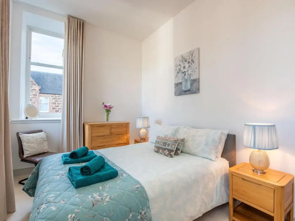 a white bedroom with a bed and a window at Apartment Great Glen View by Interhome in Inverness