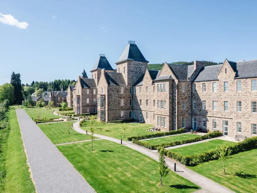 an exterior view of a large stone building with a garden at Apartment Great Glen View by Interhome in Inverness