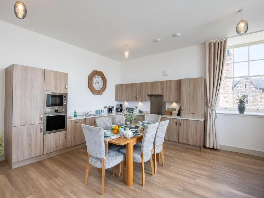 a kitchen with a wooden table and chairs at Apartment Great Glen View by Interhome in Inverness