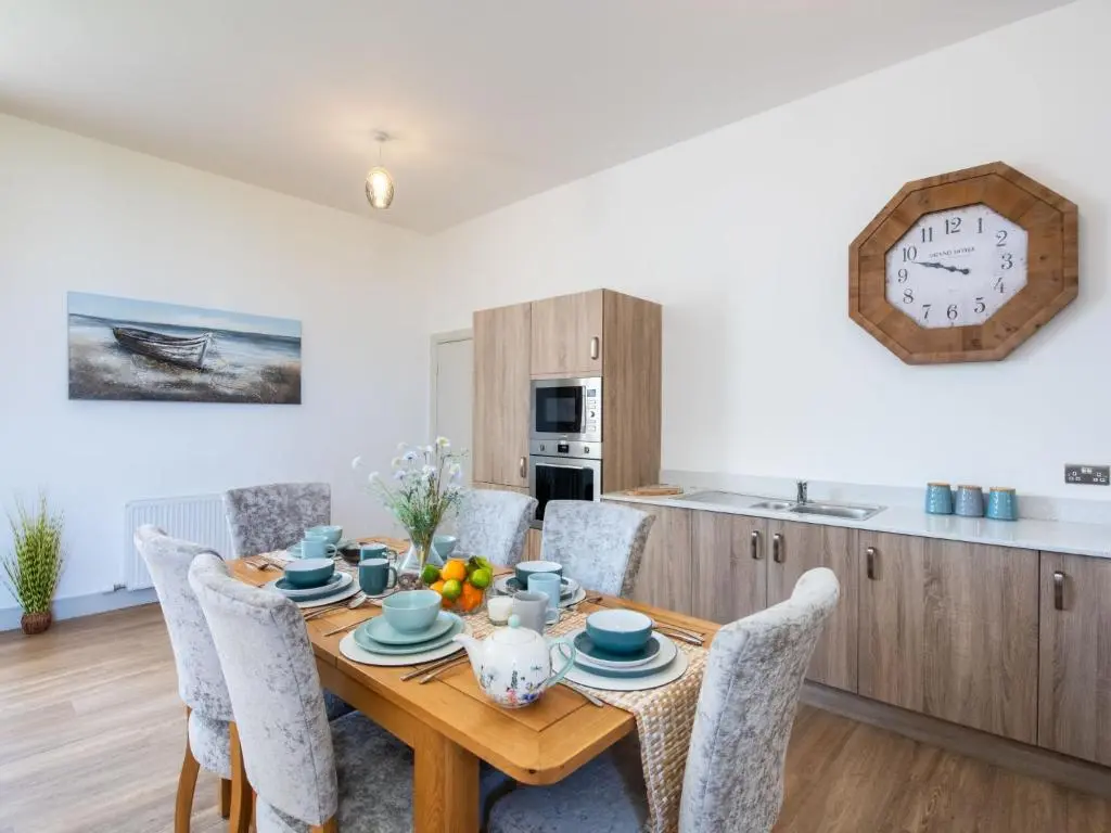 a kitchen and dining room with a wooden table and chairs at Apartment Great Glen View by Interhome in Inverness