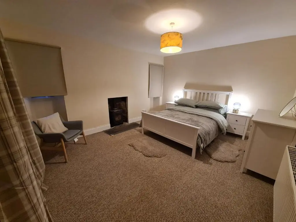 a bedroom with a bed and a desk and a chair at Alltachbeg in Tomintoul