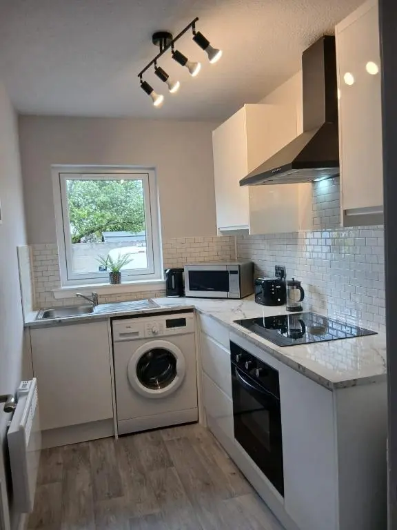 a kitchen with a washing machine and a window at Modern ground floor flat, Inverness city in Inverness