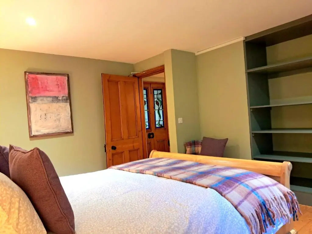 a bedroom with a bed and a wooden door at Apartment 42b by the river in Inverness