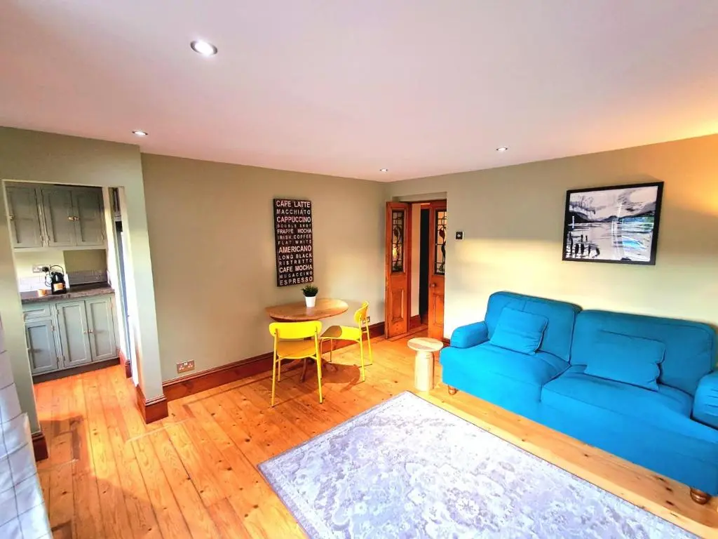 a living room with a blue couch and a table at Apartment 42b by the river in Inverness