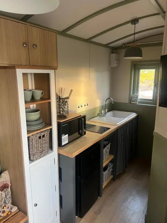 a kitchen with a sink and a microwave at Shephards Hut by the Beach in Findhorn