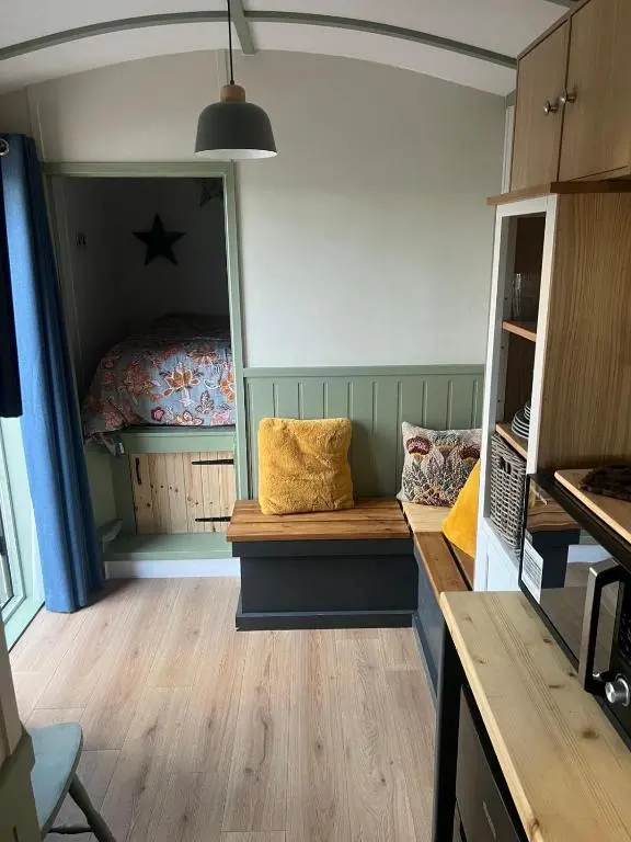 a bedroom with a bed and a bench in a room at Shephards Hut by the Beach in Findhorn