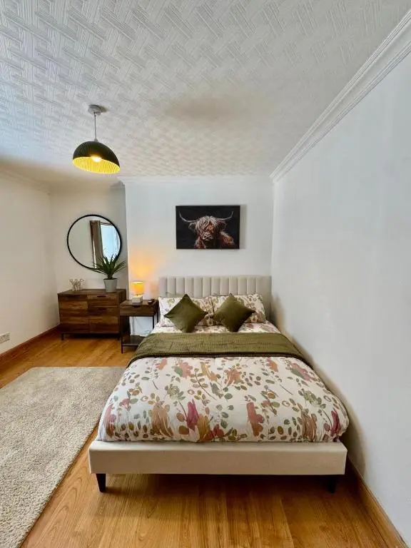 a bedroom with a bed and a mirror at The Ivy Nest, central in Inverness
