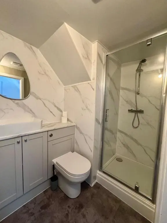 a white bathroom with a shower and a toilet at The Ivy Nest, central in Inverness