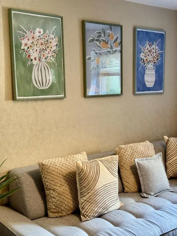 a living room with a couch and three pictures on the wall at The Ivy Nest, central in Inverness