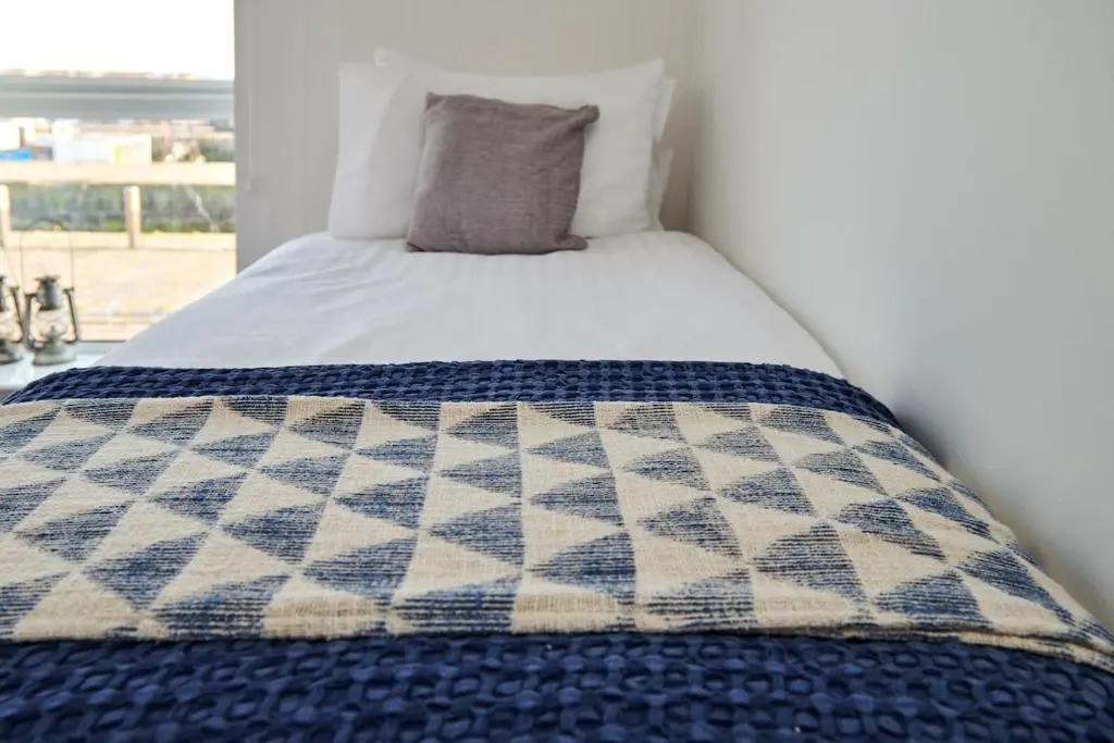 a bed with a blue and white quilt on it at The Sandpiper in Burghead