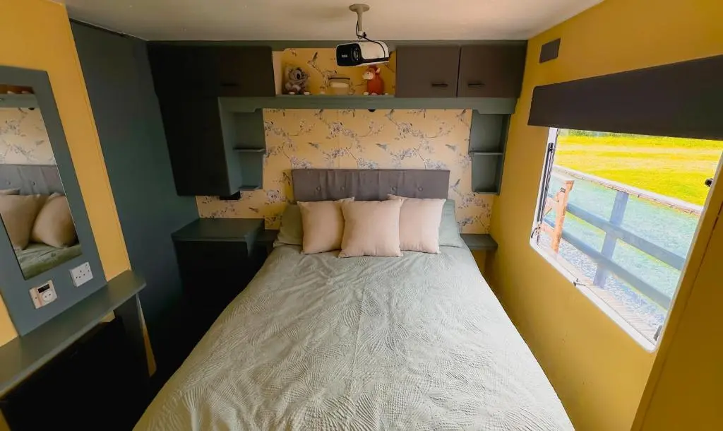 a small bedroom with a bed and a window at Caravan Nr 51 Only for Family Holiday