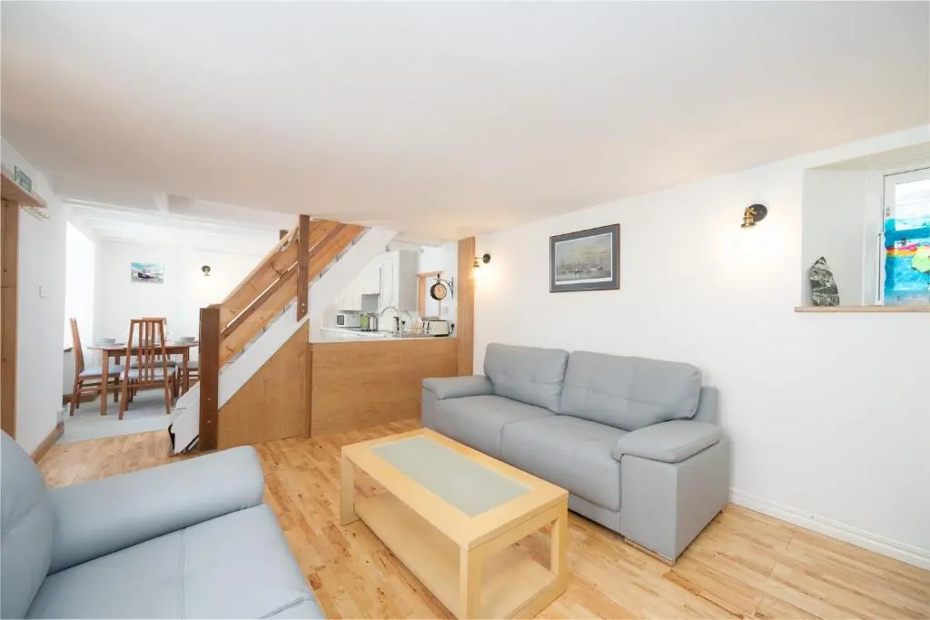 a living room with a couch and a table at Seabreeze Cottage, 17 Seatown, Gardenstown in Gardenstown