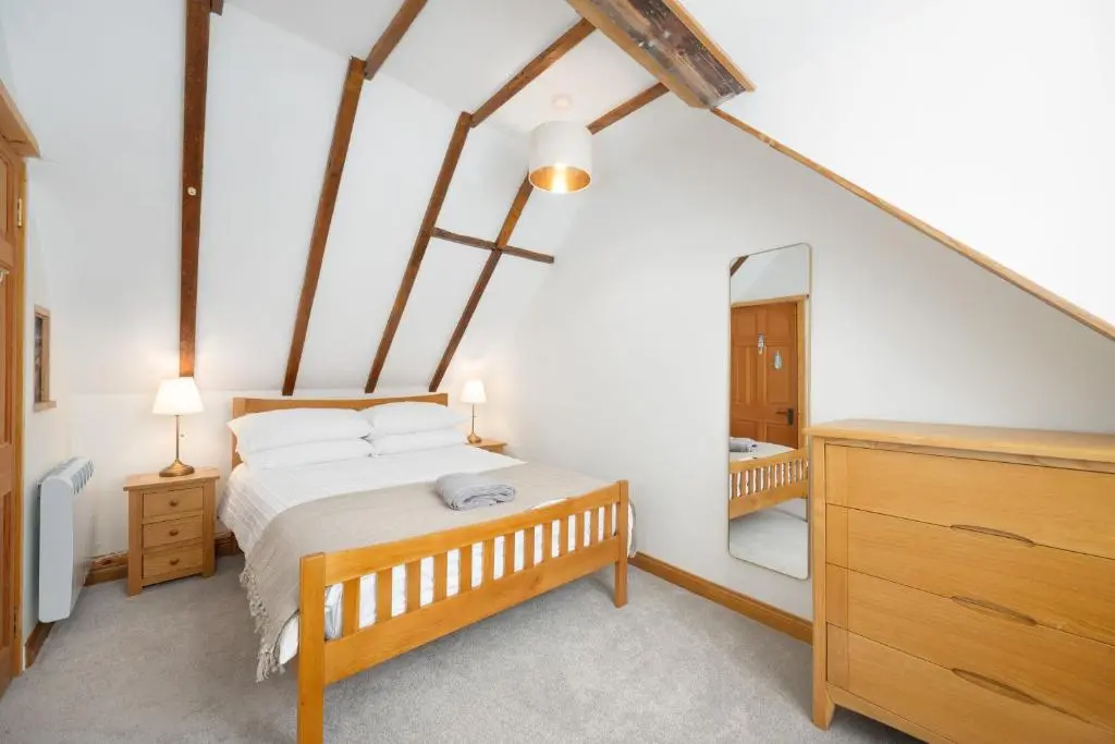 a bedroom with a bed and a dresser and a mirror at Seabreeze Cottage, 17 Seatown, Gardenstown in Gardenstown