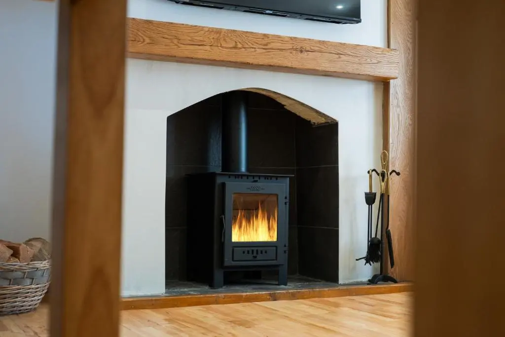 a fireplace with a fire in it in a room at Nautical Nook, 16 Seatown, Gardenstown in Gardenstown