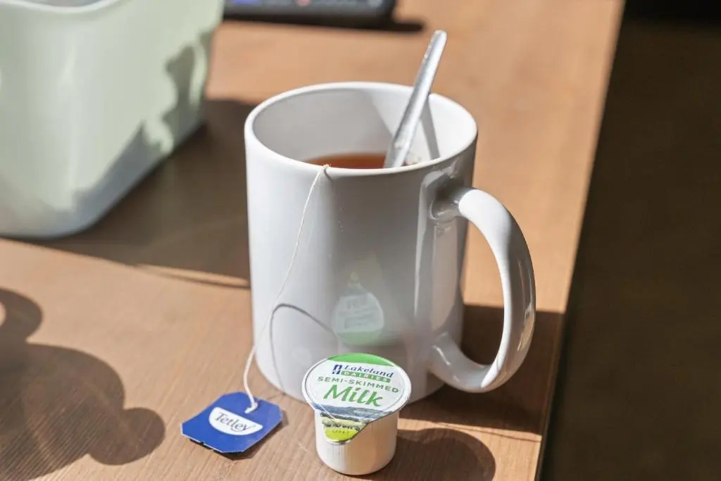 a cup of coffee with a spoon in it at mySTAYINN Cedar Villa 9 Bedroom House - Inverness in Inverness